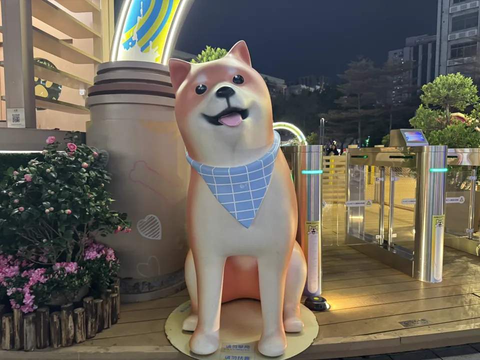 夜色中戴着蓝色领巾的柴犬雕塑