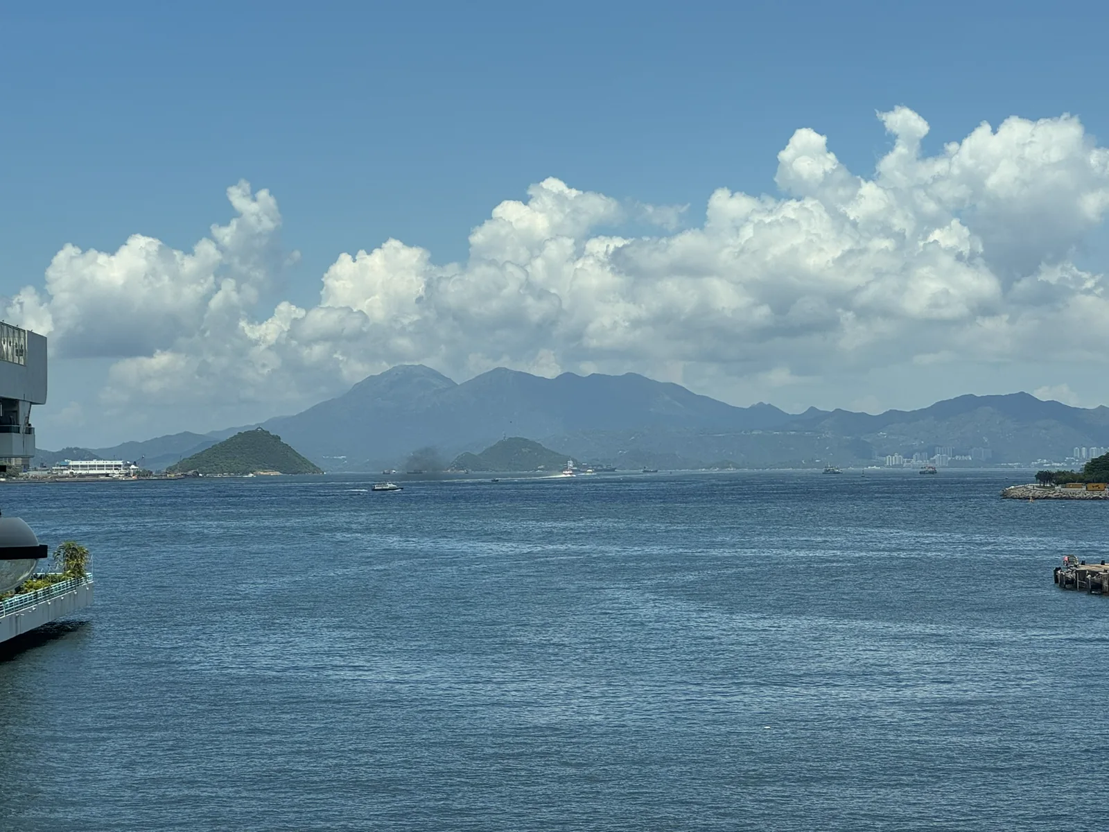 晴空下蓝色海面与远处连绵山脉