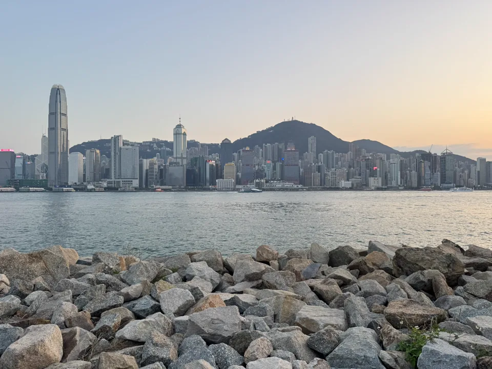 礁石前的海面与暮色中的香港楼群