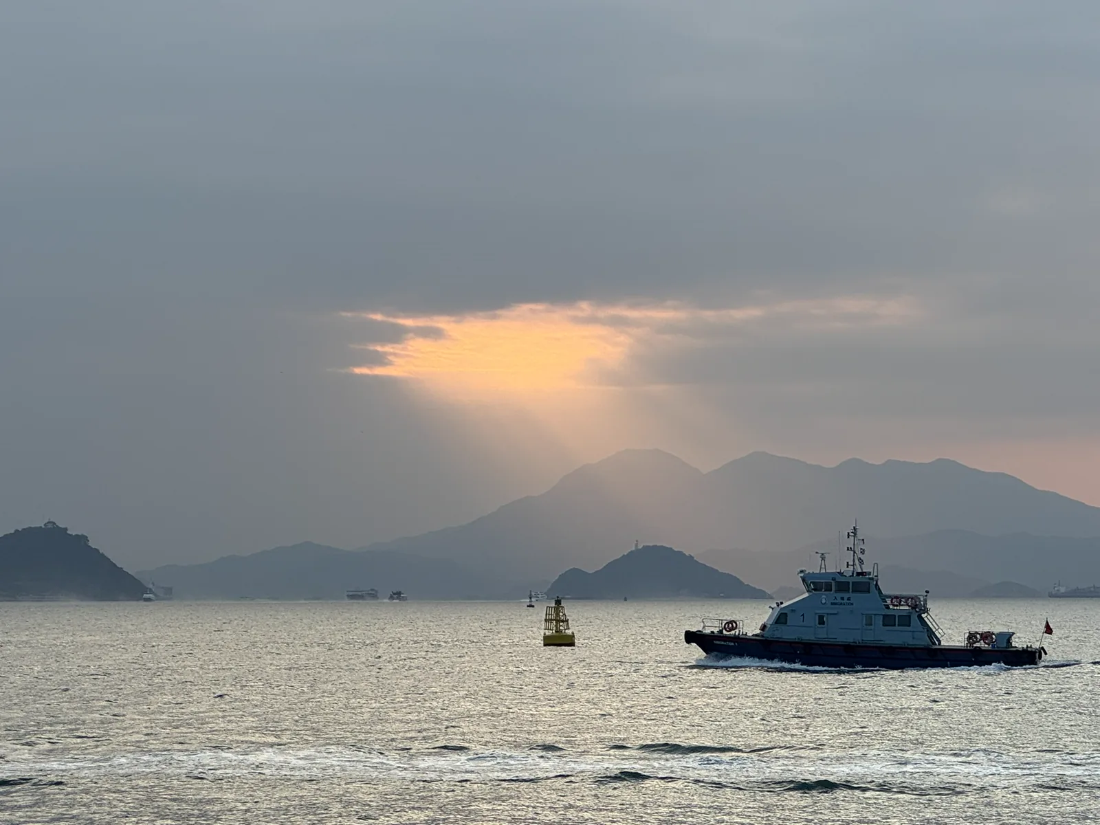 薄雾与阳光中的海面、远山和渡船