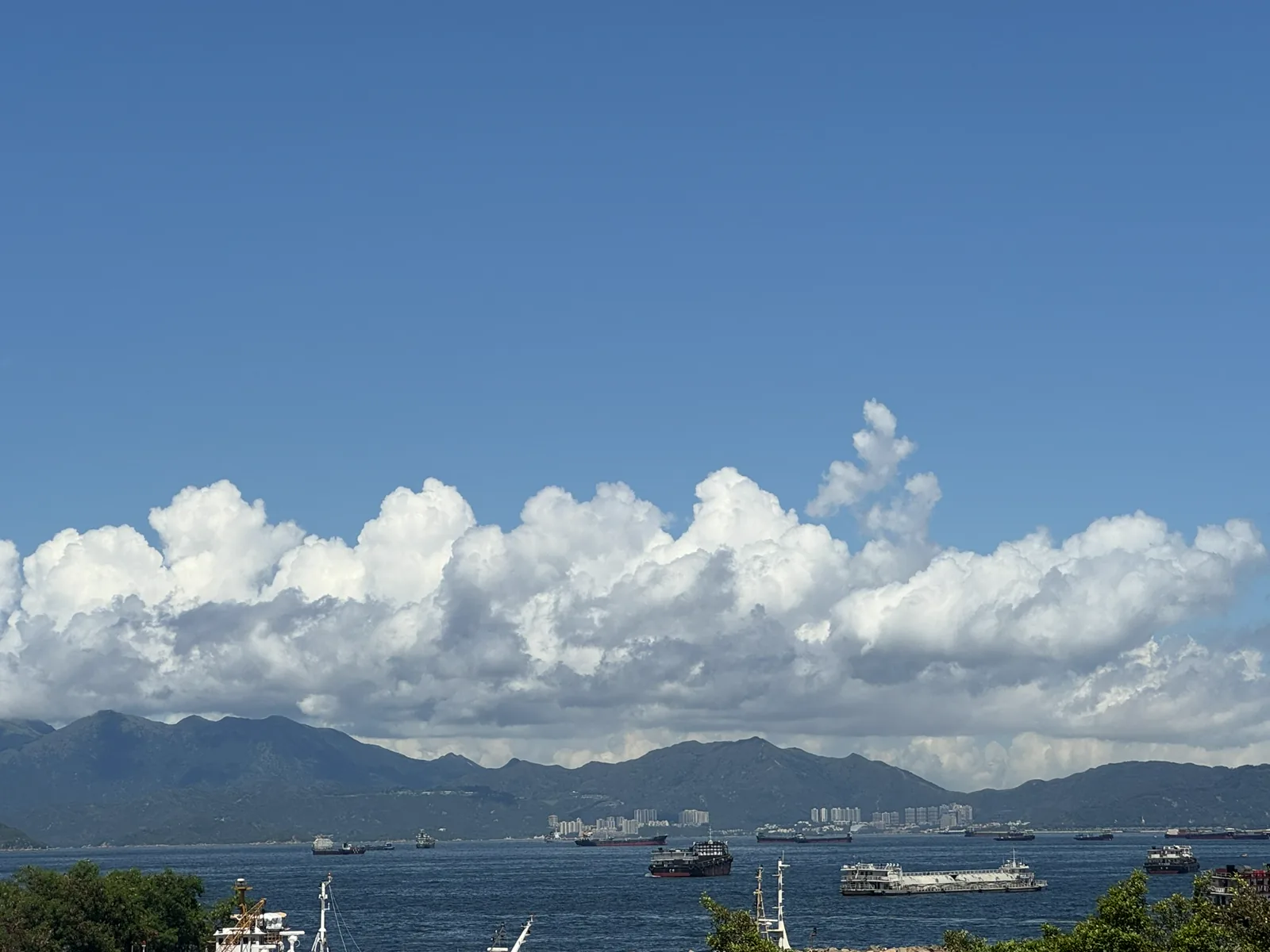 大片云层覆盖山脉与繁忙海湾